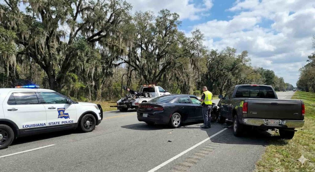 Louisiana State Police Officer documenting a multi-vehicle collision on a highway, illustrating the importance of a police report for a car accident injury claim.